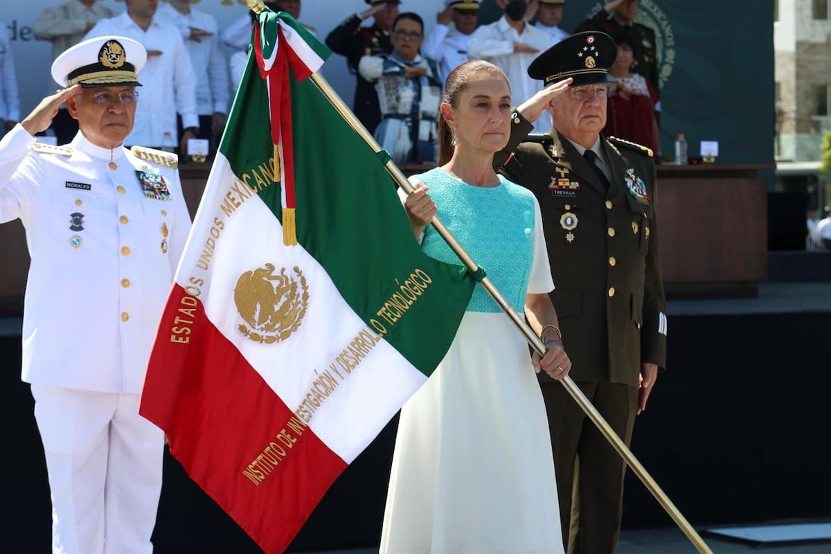 Claudia Sheinbaum sostiene una bandera junto a mandos de la Marina y la Defensa